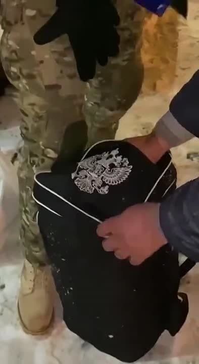 В сети расходятся кадры, на которых, предположительно, в Харькове люди в военной форме остановили прохожего и вырезали с его сумки надпись «Россия» и герб