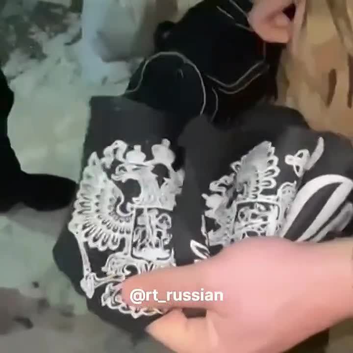 В сети расходится видео, как, предположительно, в Харькове мужчины в военной форме вырезают с сумки прохожего надпись «Россия» и герб РФ